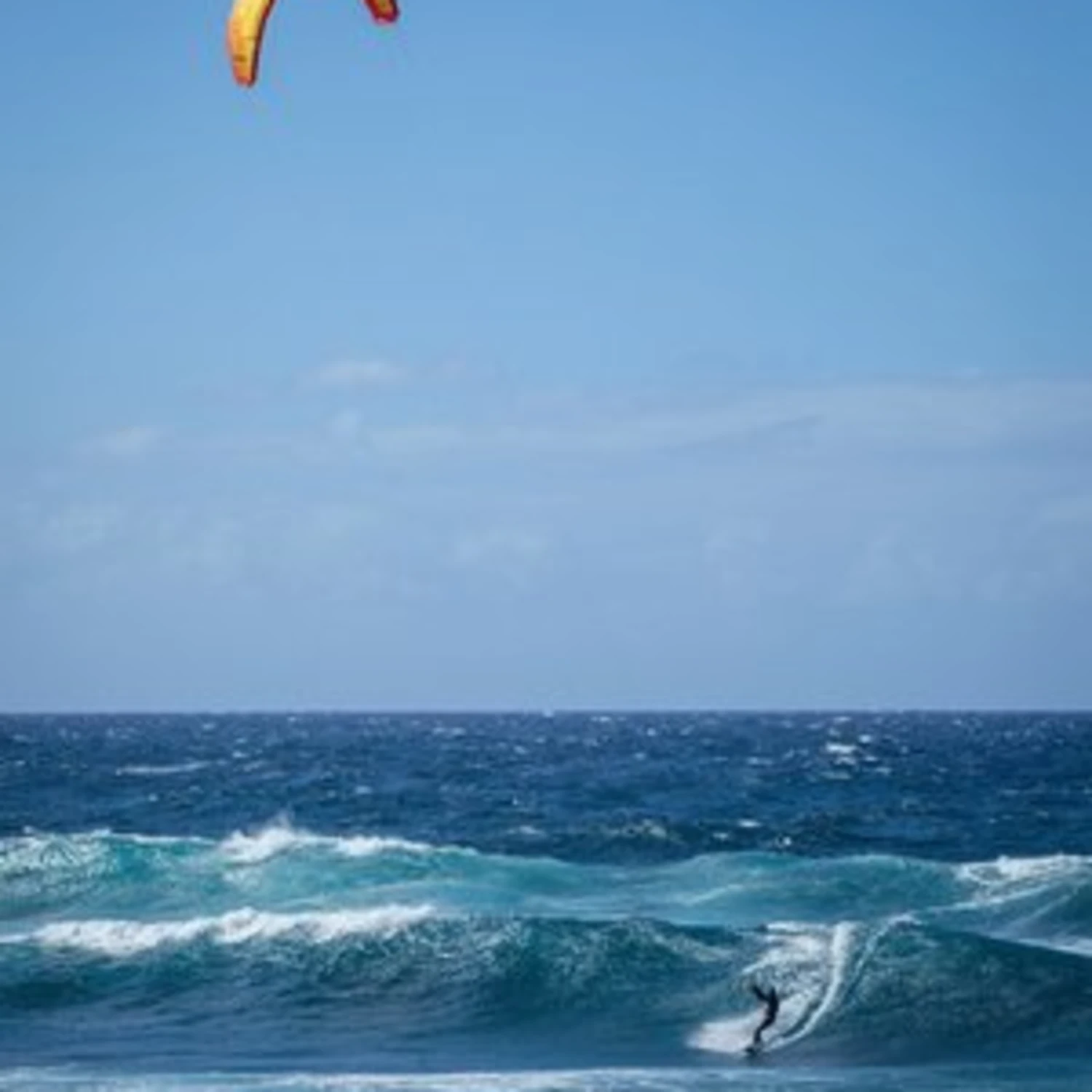 person paragliding on ocean waves