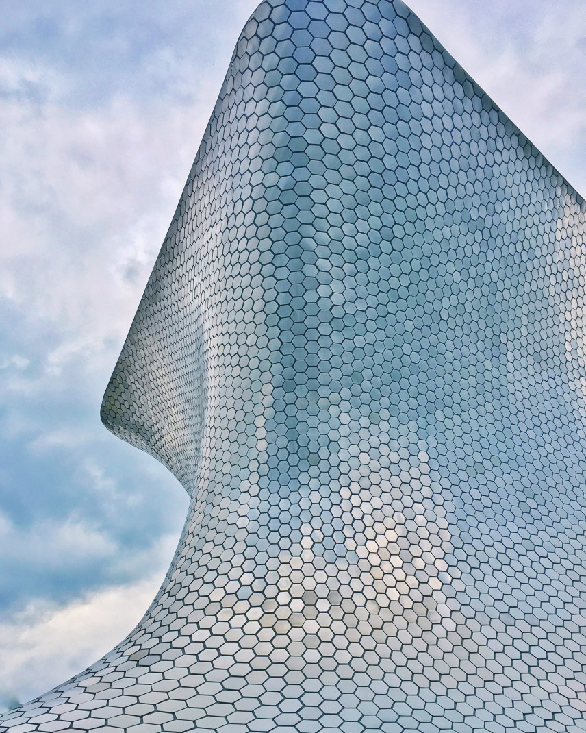 Large curved silver building in Mexico City built by architect Fernando Romero.