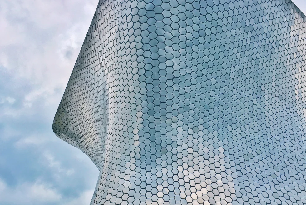 Large curved silver building in Mexico City built by architect Fernando Romero.