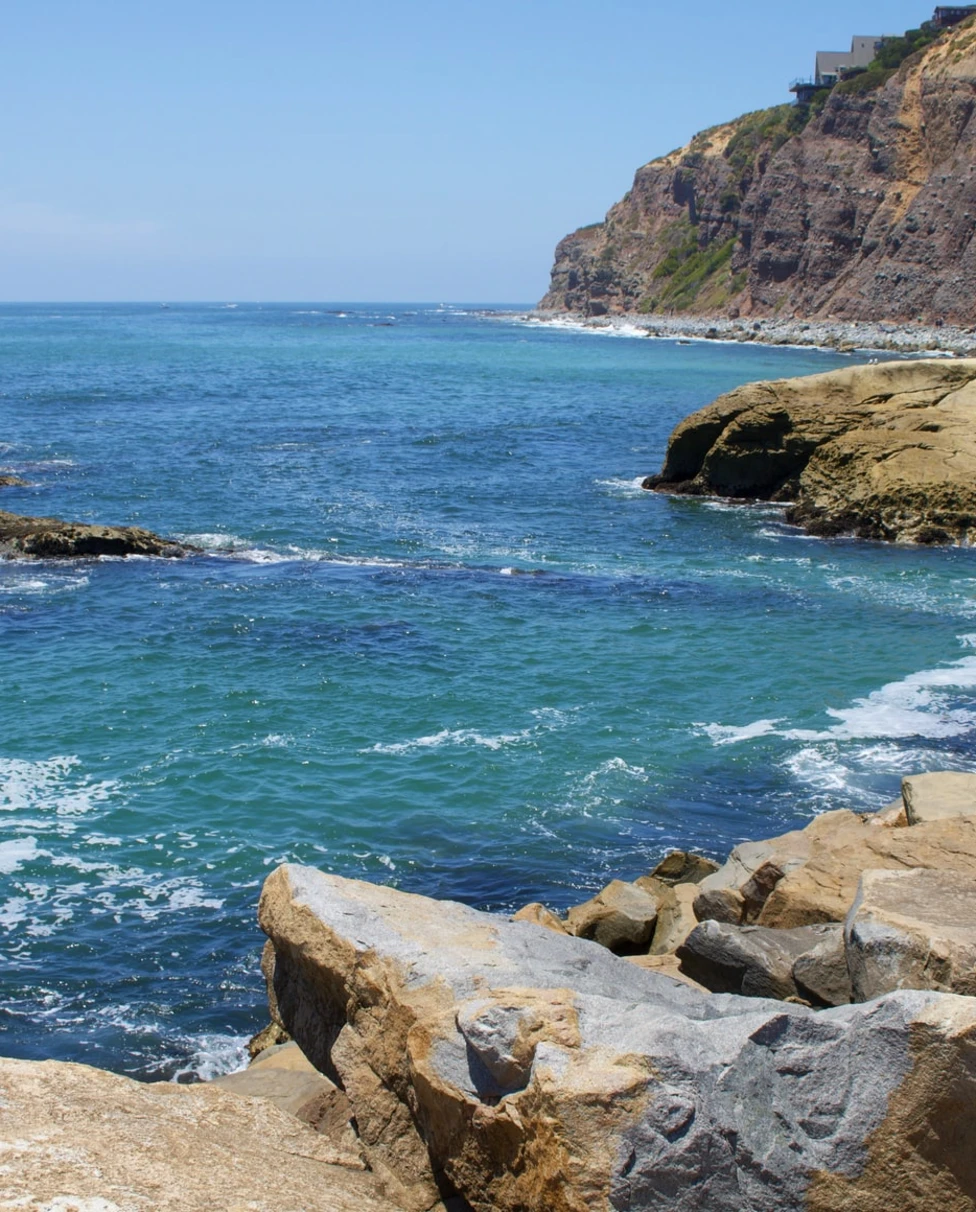 Blue ocean with cliffs and green rocks in Dana point California