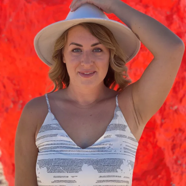 Fora travel agent Ashley Barbic wearing white hat with red background