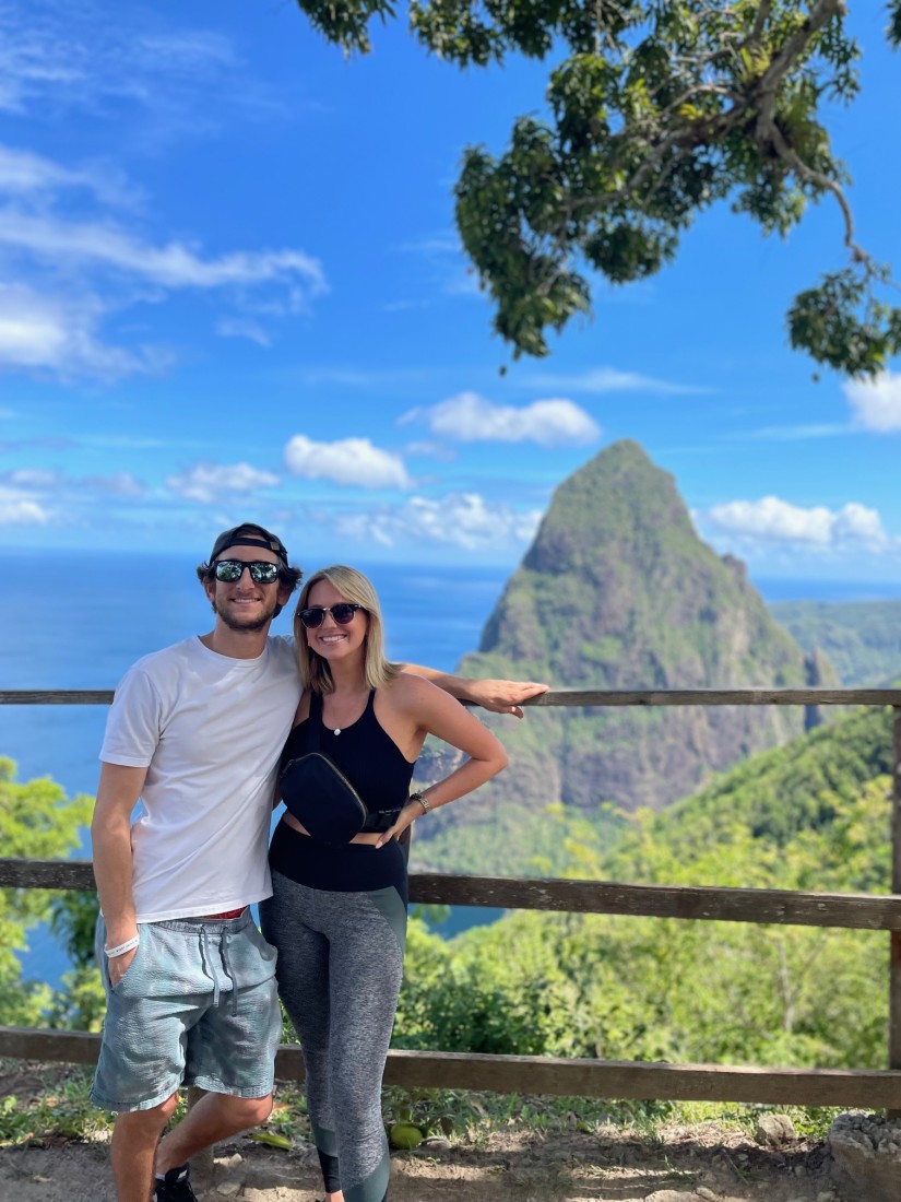 A couple posing with a view of a mountain in the distance