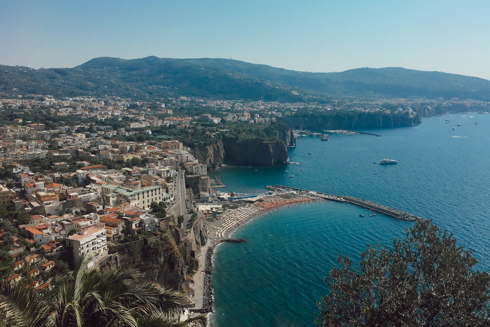 cliff with buildings next to body of water during daytime