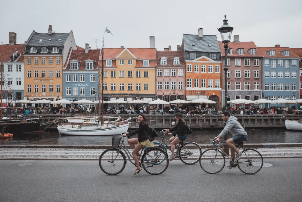 People cycling on the road in front of colorful buildings
