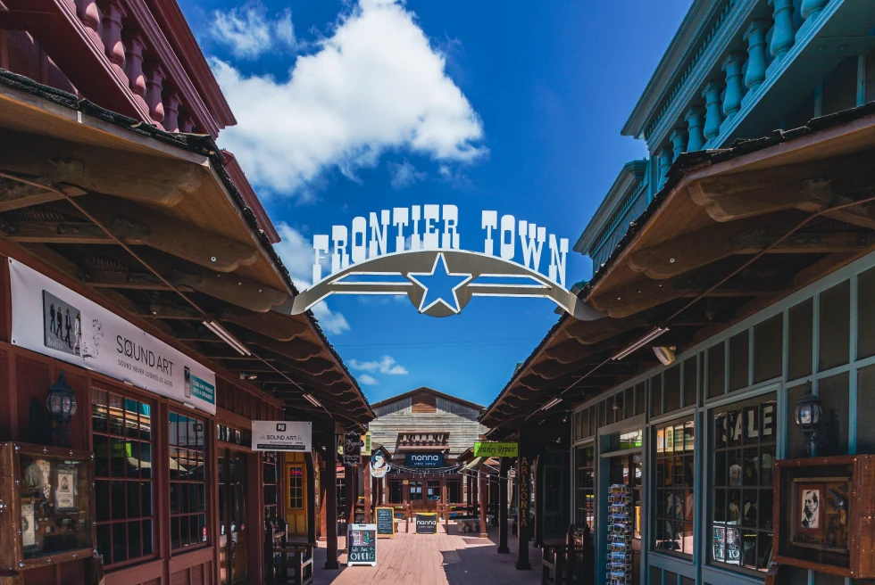 Storefronts with frontier town sign hanging on a sunny day