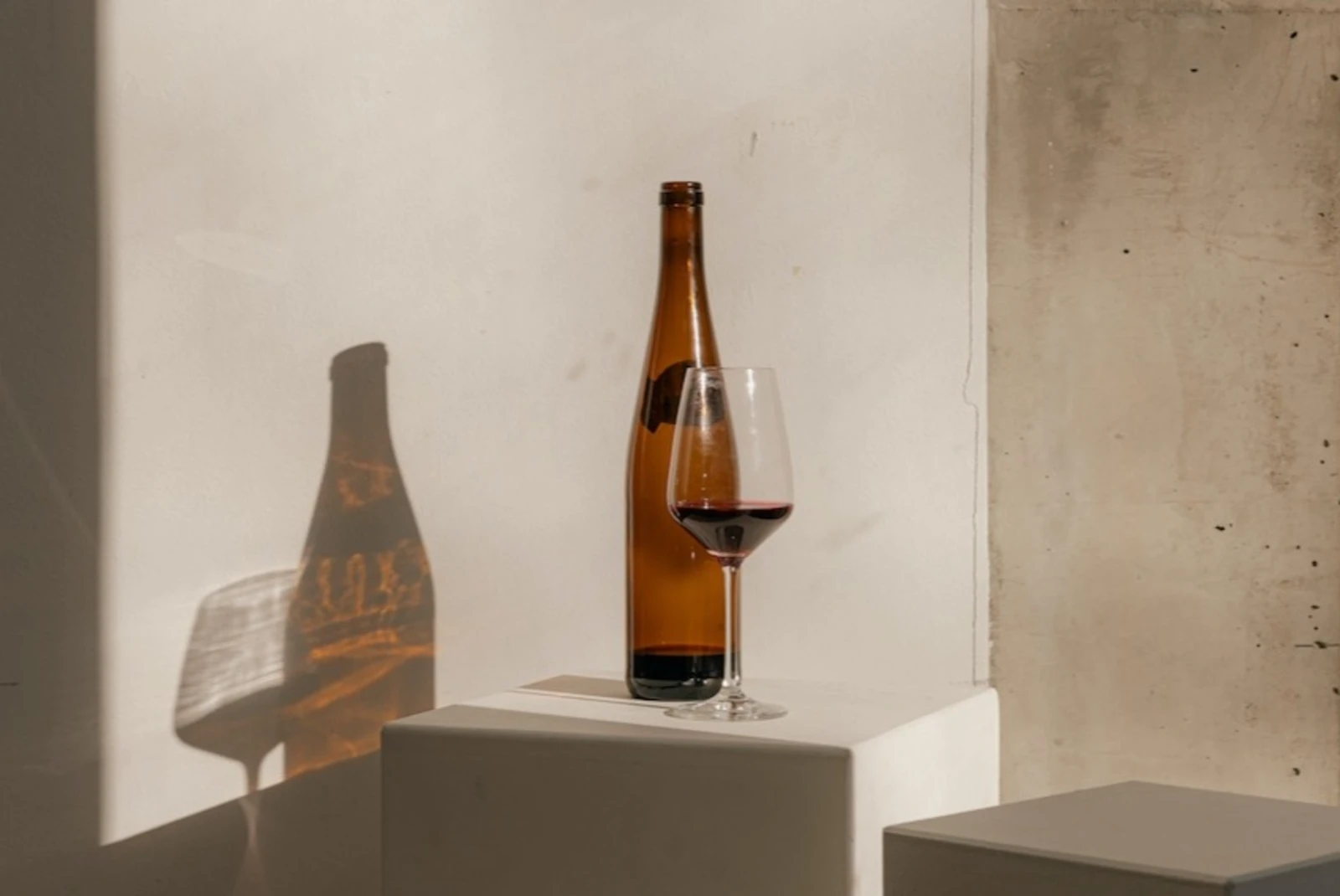 wine glass and bottle on a white block