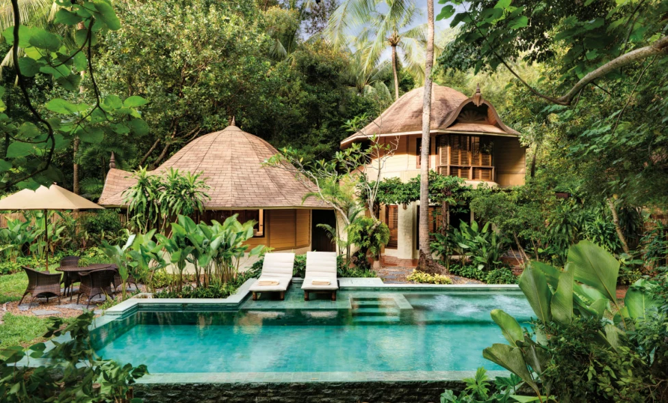 domed buildings overlook a luxe pool in a lush jungle 