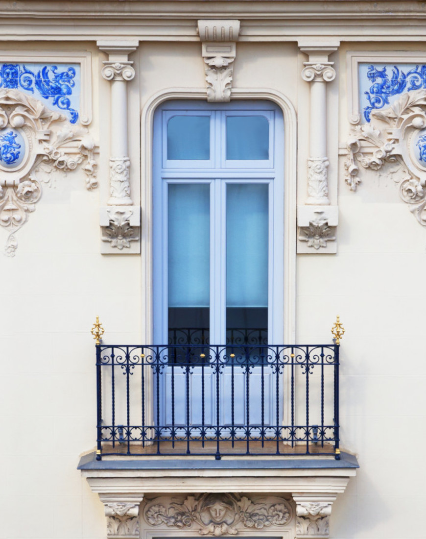 a blue window on an ornate cream-colored building