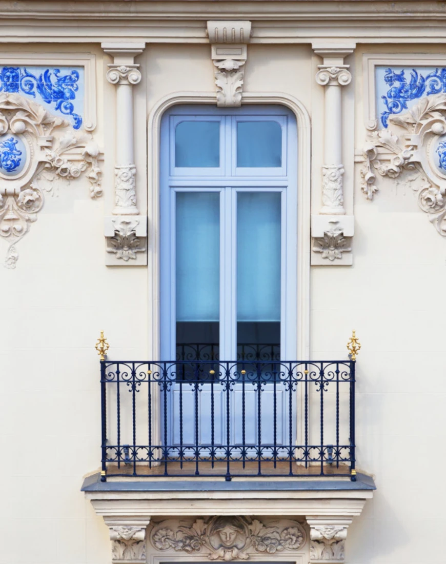 a blue window on an ornate cream-colored building