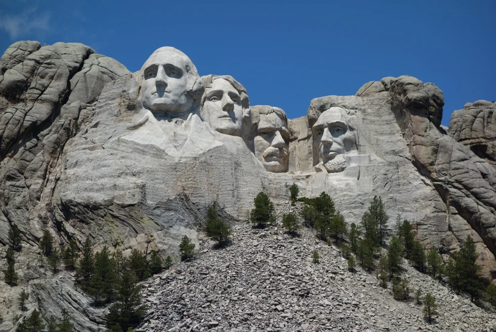 sculptures of faces on the side of the mountain