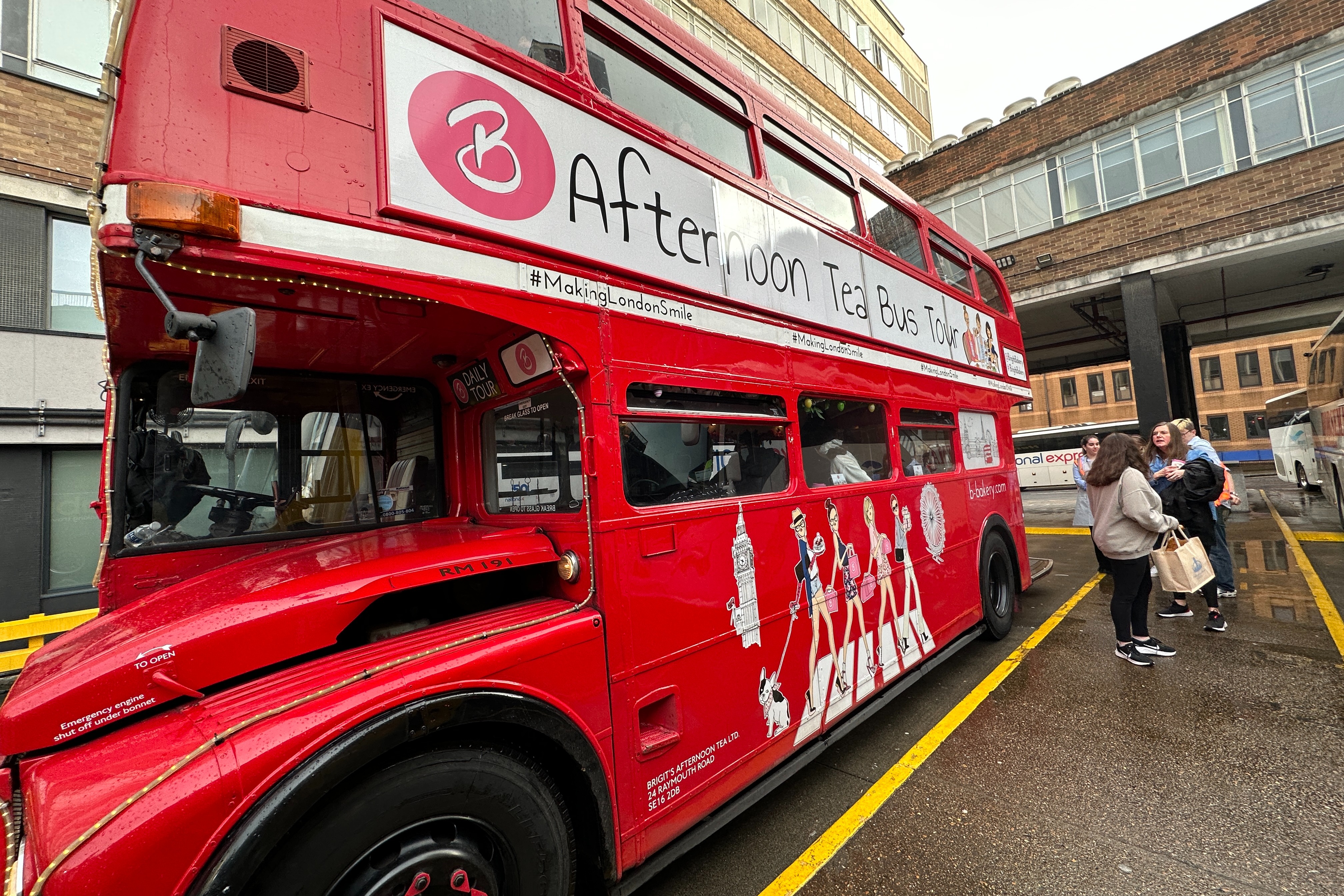 Red double decker bus on the road with people