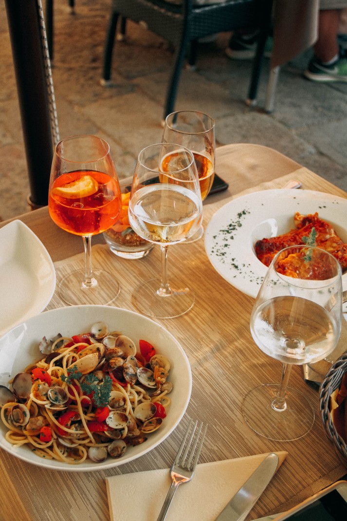 two aperol spritz and a plate of food on a wooden table