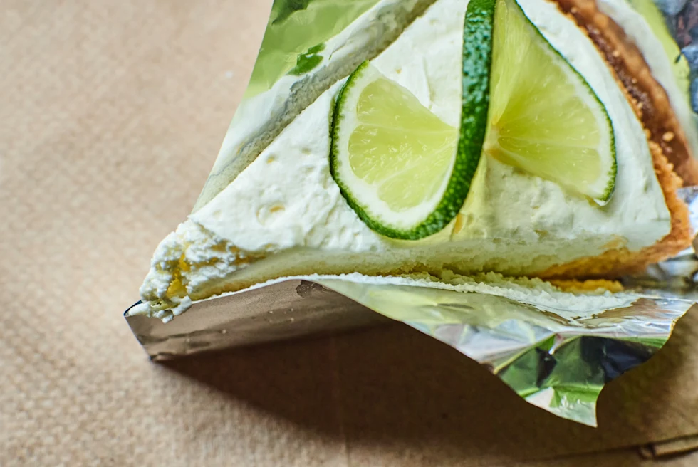 Slice of key lime pie on a brown napkin