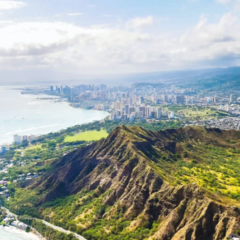 aerial view of mountains next to body of water and city