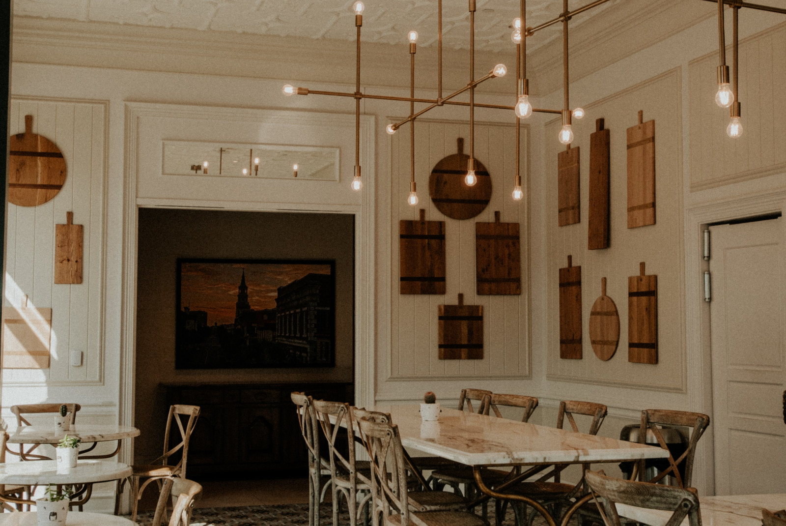 tables and chairs in a room with white walls