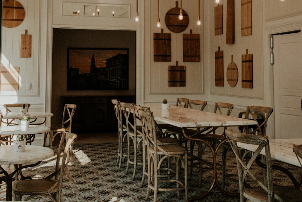 tables and chairs in a room with white walls