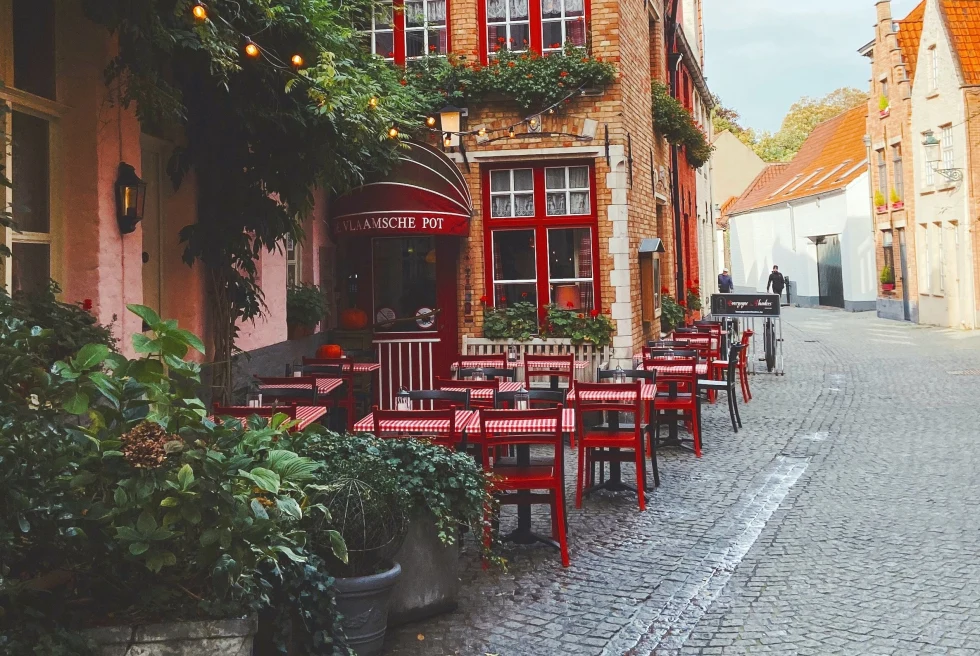 red tables and chairs outside next to brick building