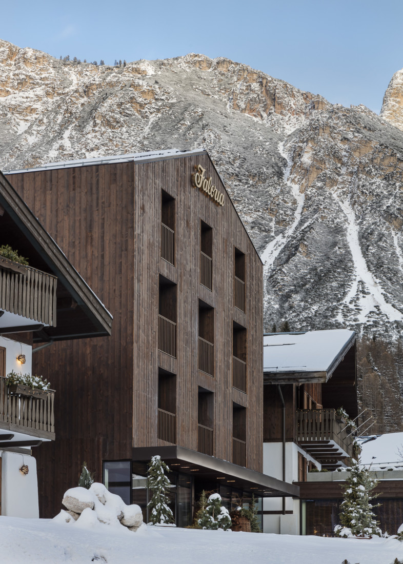 a wooden building in front of a snowy mountain