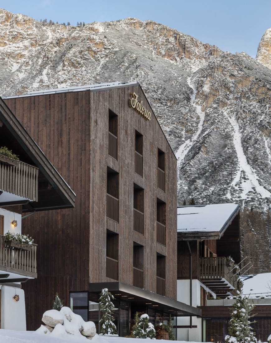 a wooden building in front of a snowy mountain