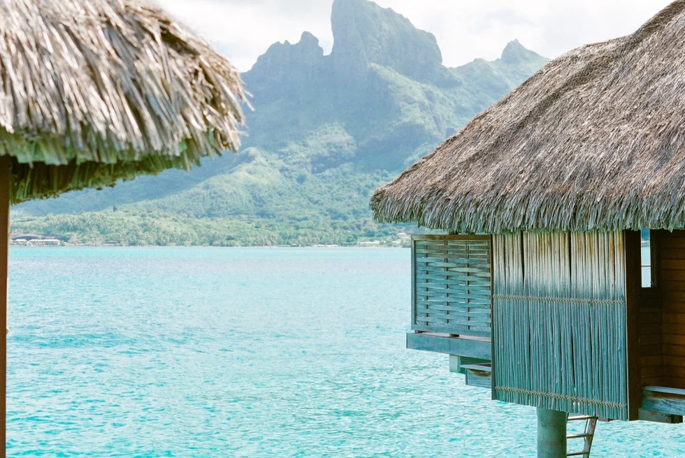 overwater bungalow overlooking a rugged green mountain