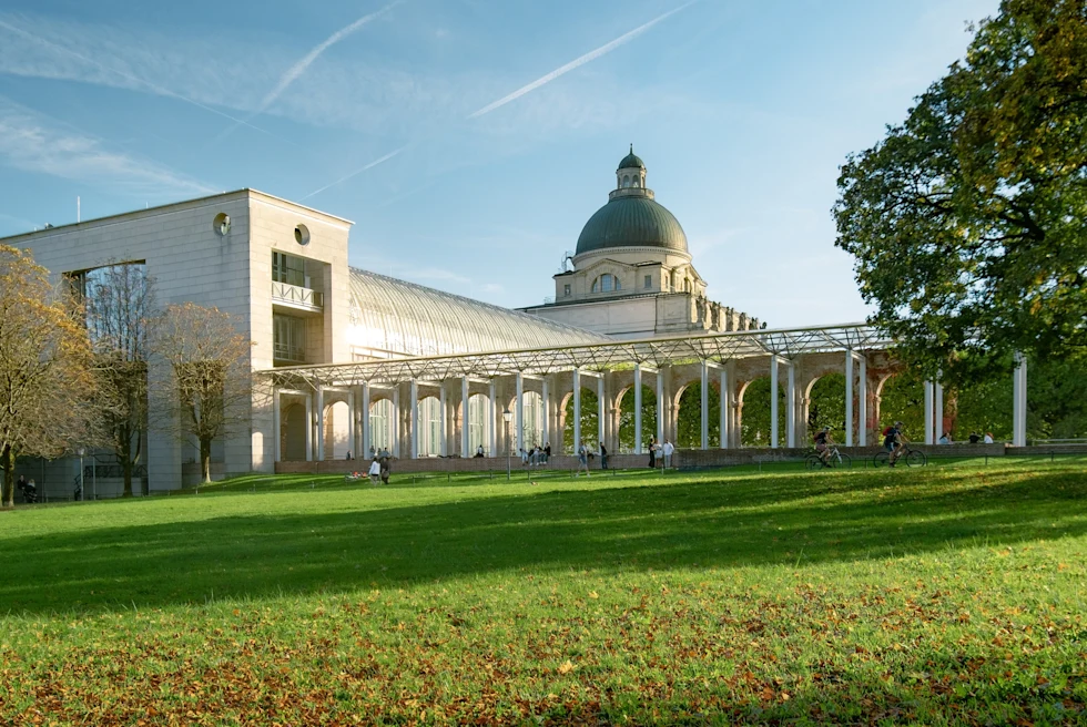 A green garden and a grey dome of the Bavarian State Chancellery