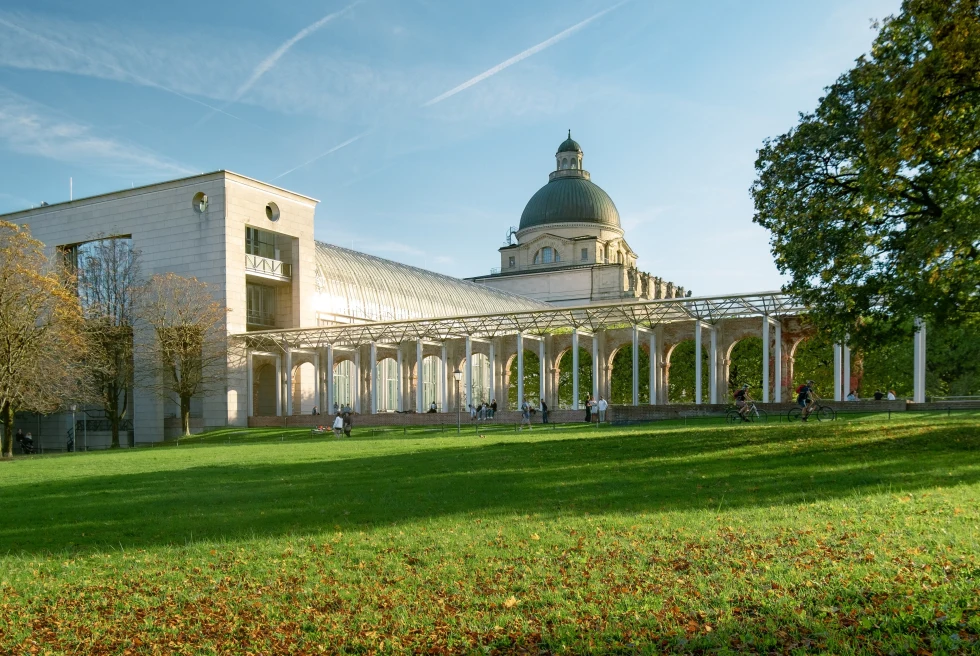 A green garden and a grey dome of the Bavarian State Chancellery