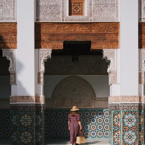 woman standing next to building with colorful tile during daytime