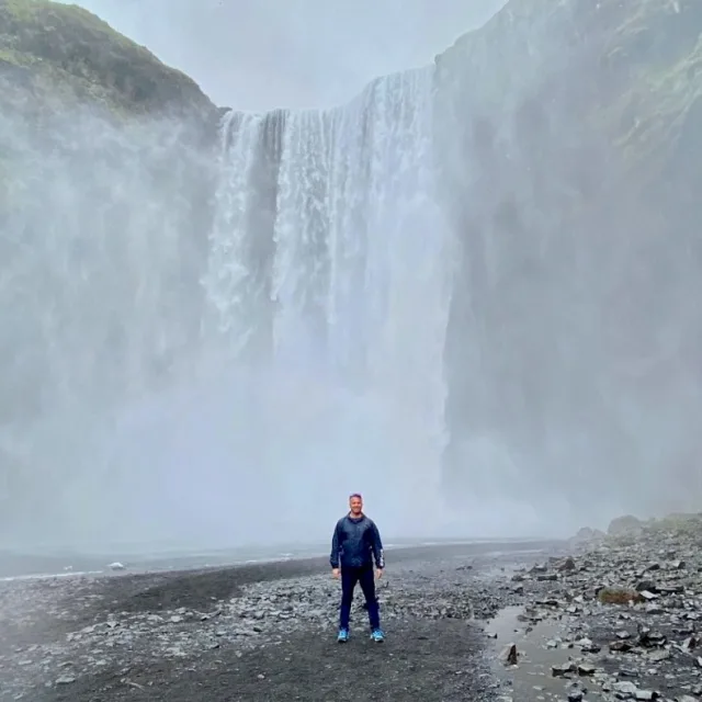Kevin standing in front a giant waterfall