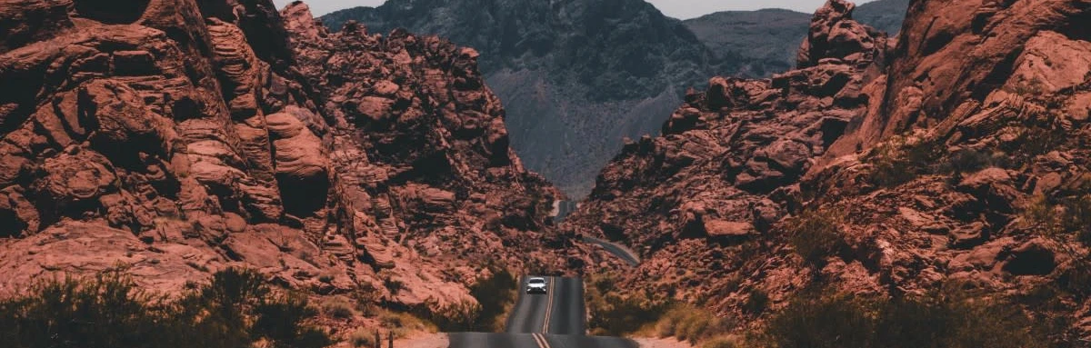 Long open road heading straight through canyons.