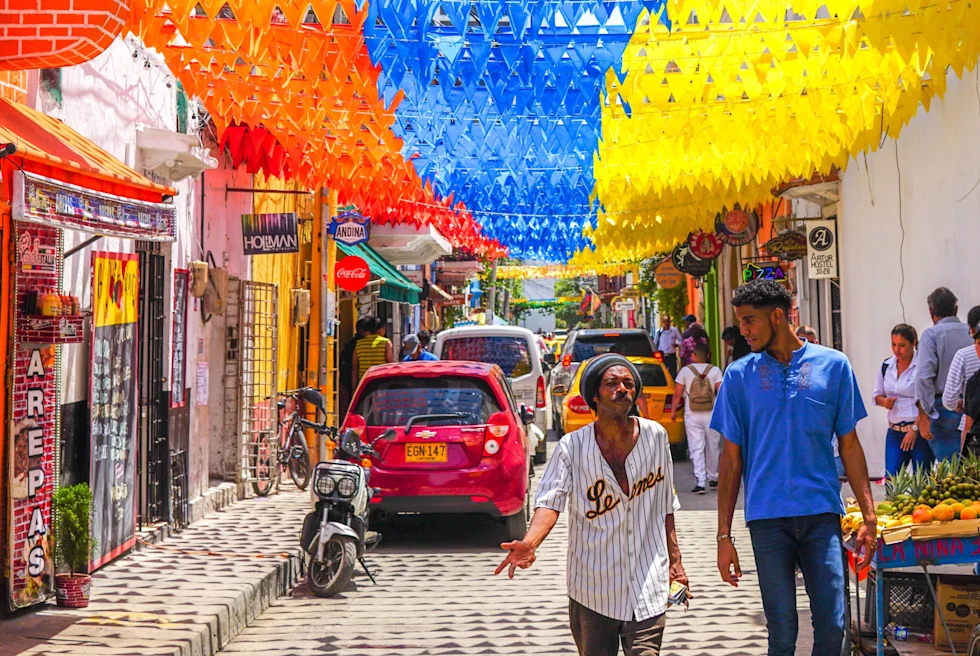 Colombia flag on the street with people, vendors and more street life.