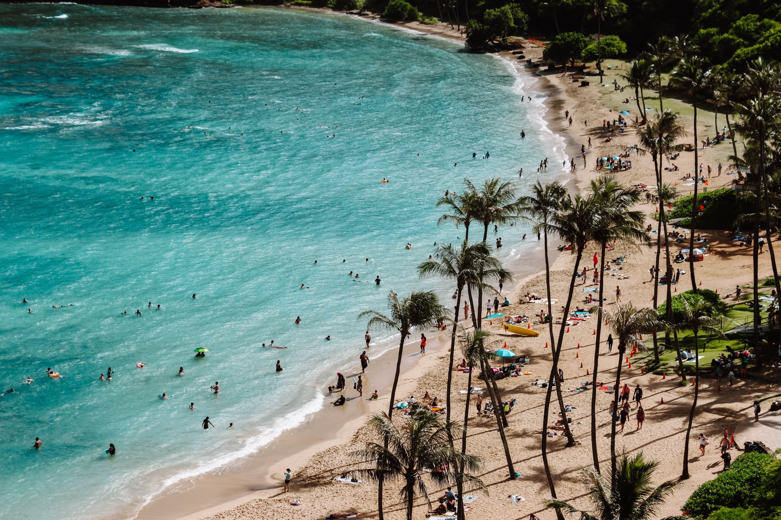 A beautiful beach in Hawaii filled with sunbathers. 