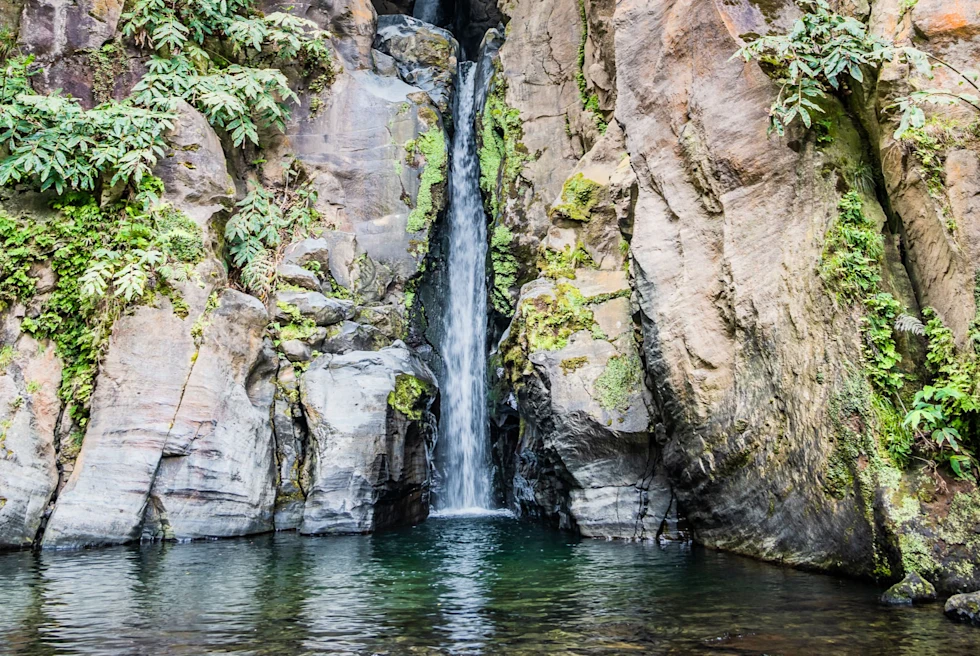 Waterfall between rocky hills.