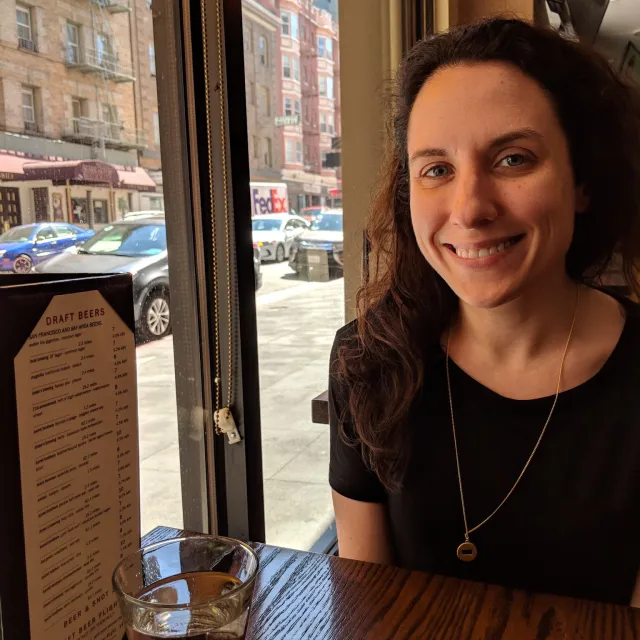 Travel Advisor Brittany Schaefer sits in a city cafe window with a drink