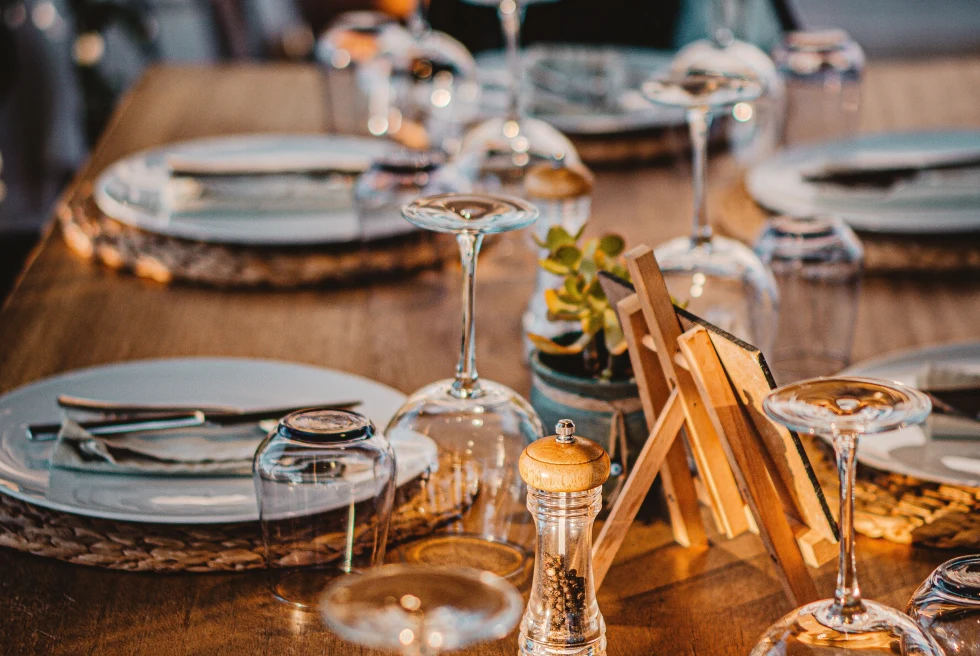 Table with wine glasses and white plates during daytime