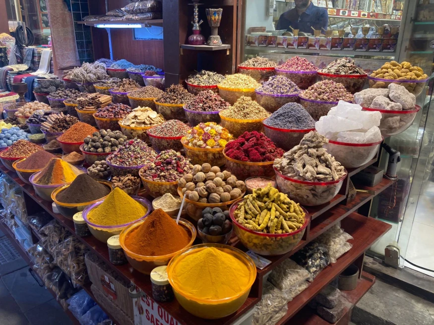bowls of colorful spices and herbs at an outdoor market
