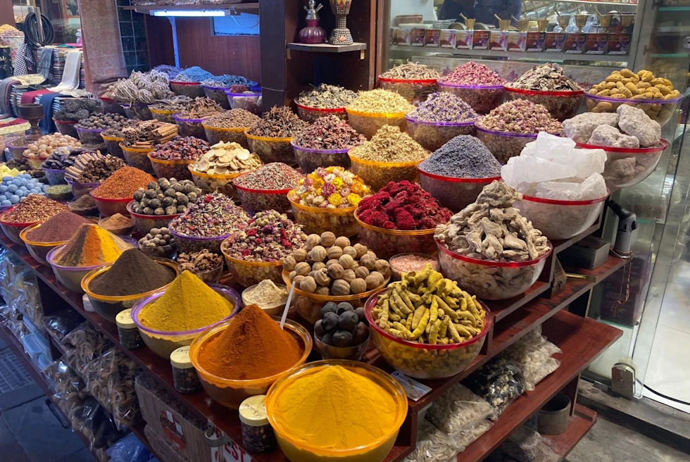 bowls of colorful spices and herbs at an outdoor market
