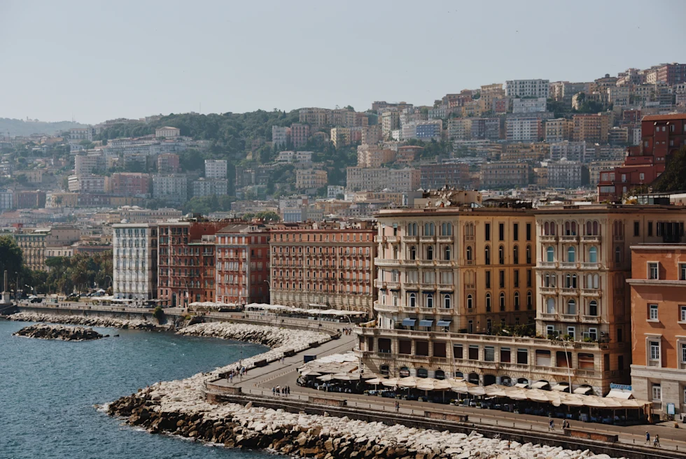 Colorful buildings on hills surrounding the blue sea.