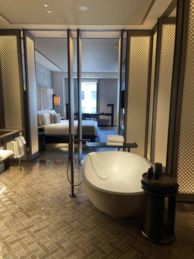 Inside the bathroom, with a modern-style tub and sink, with the option to close or open blinder-style doors.