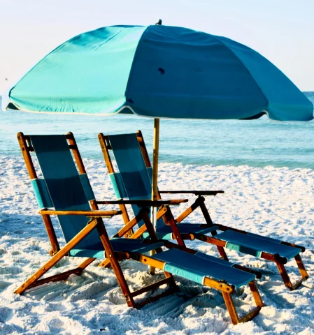 Two beach chairs with blue umbrella on the beach