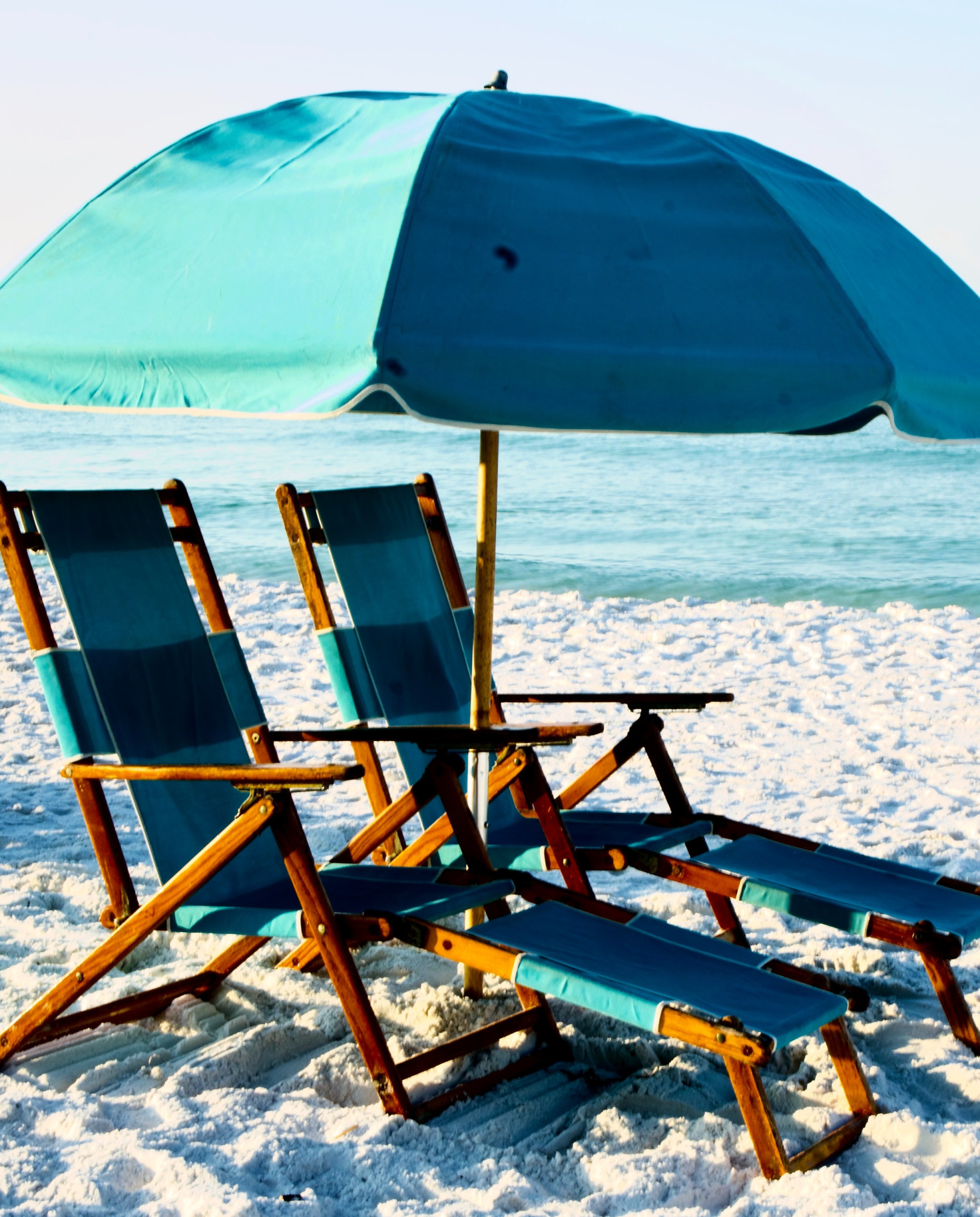 Two beach chairs with blue umbrella on the beach