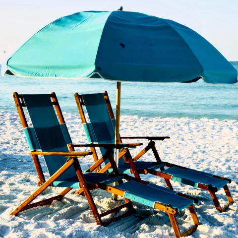 Two beach chairs with blue umbrella on the beach