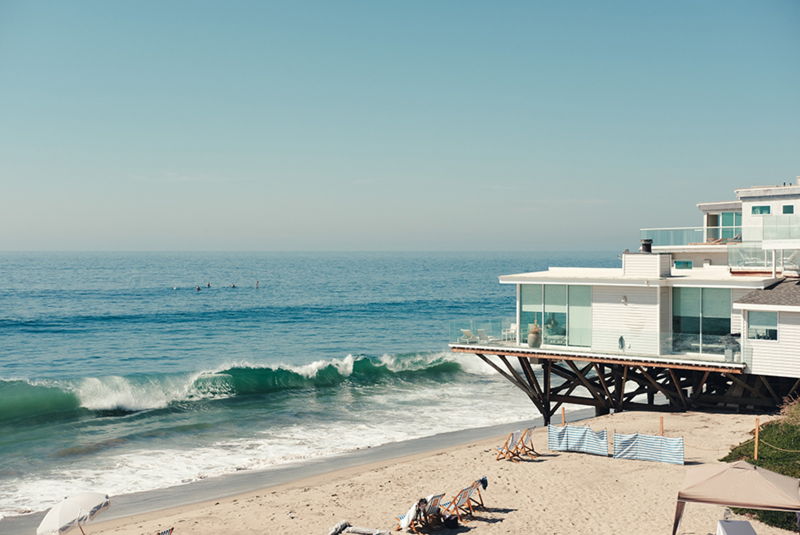 Malibu California beach blue water waves white house and beach chairs