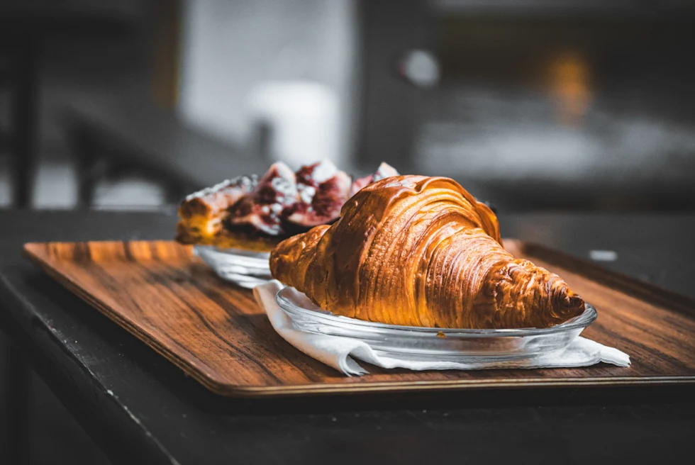 A close up of food plate with croissant.