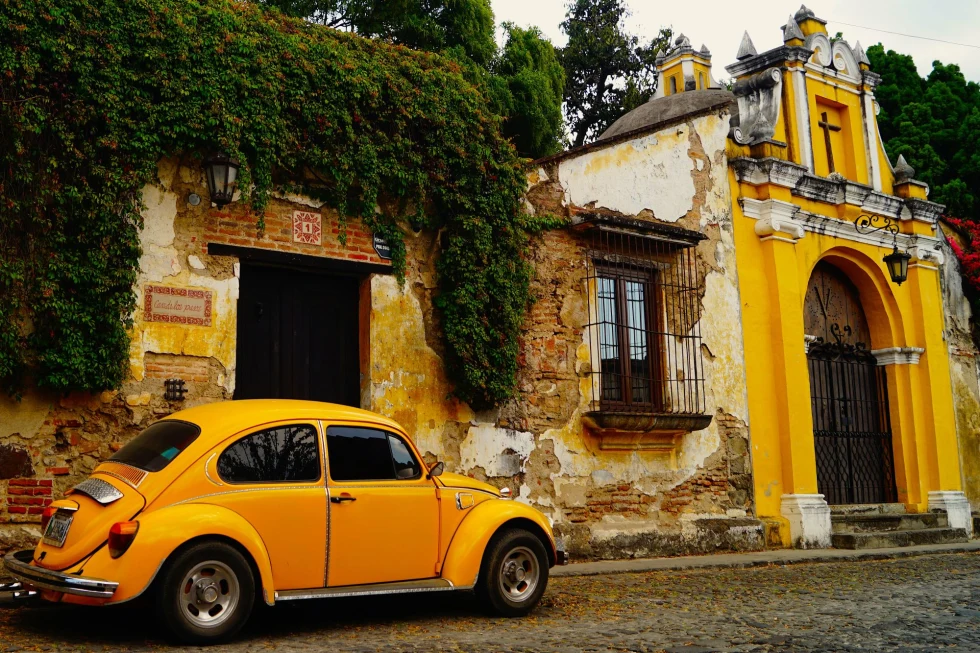 historic yellow building with a yellow car parked on the street in front