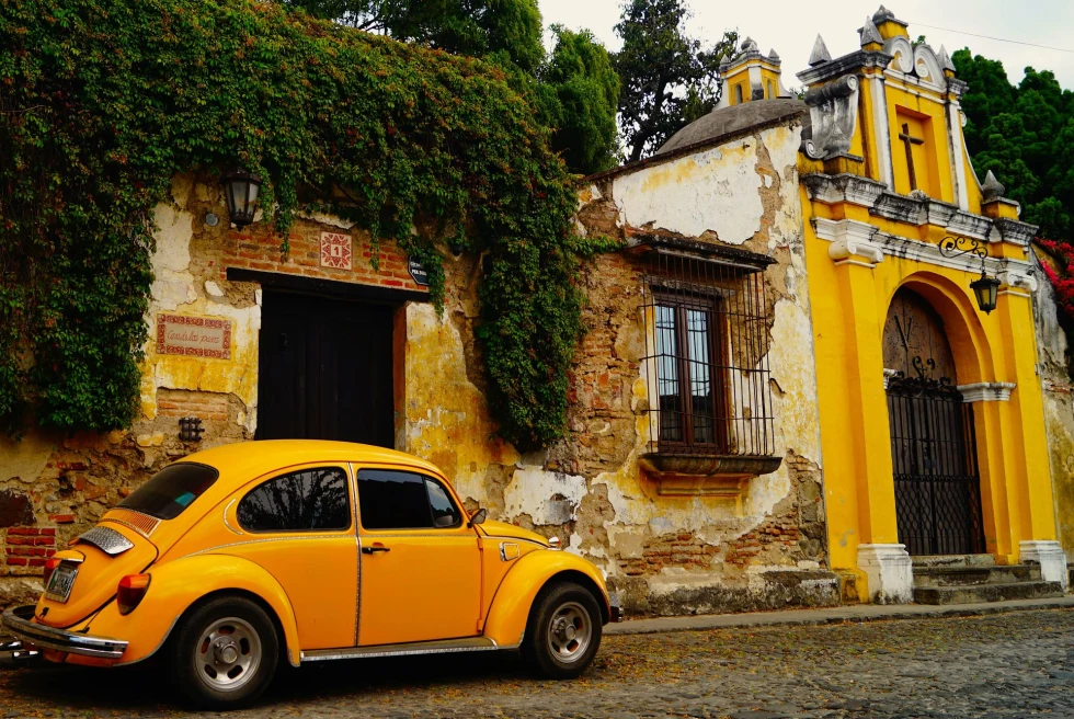 historic yellow building with a yellow car parked on the street in front