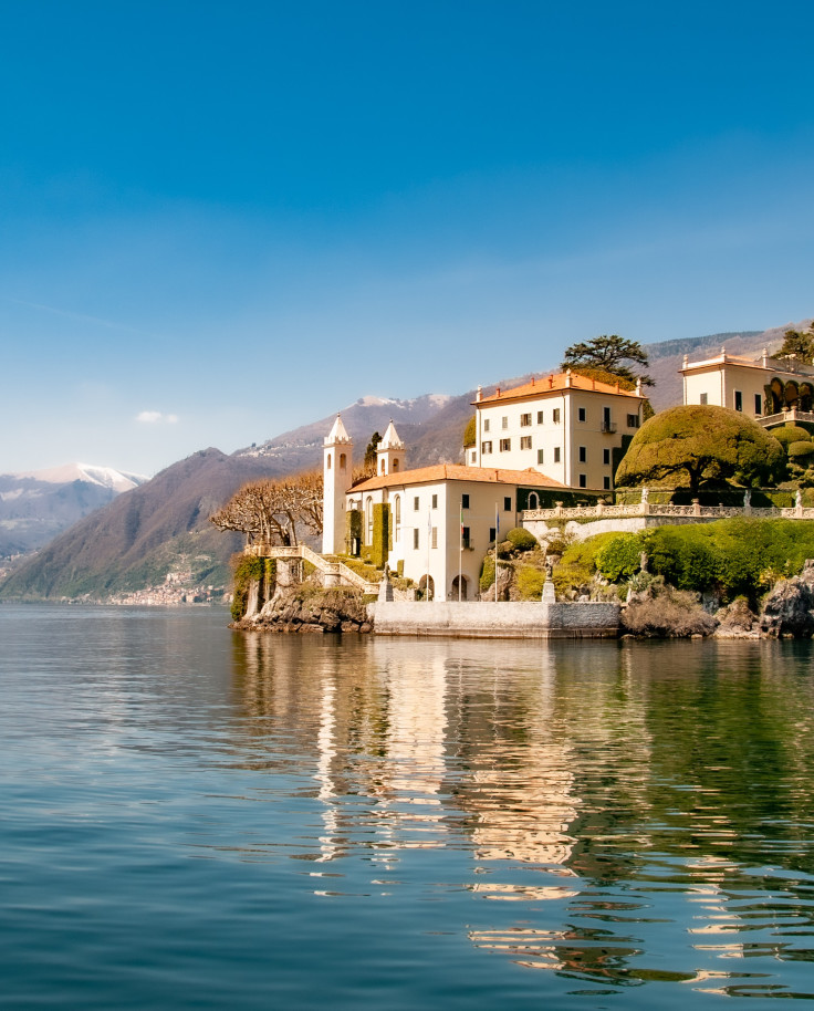 White houses with orange roofs sitting lakeside at Lake Como in Italy