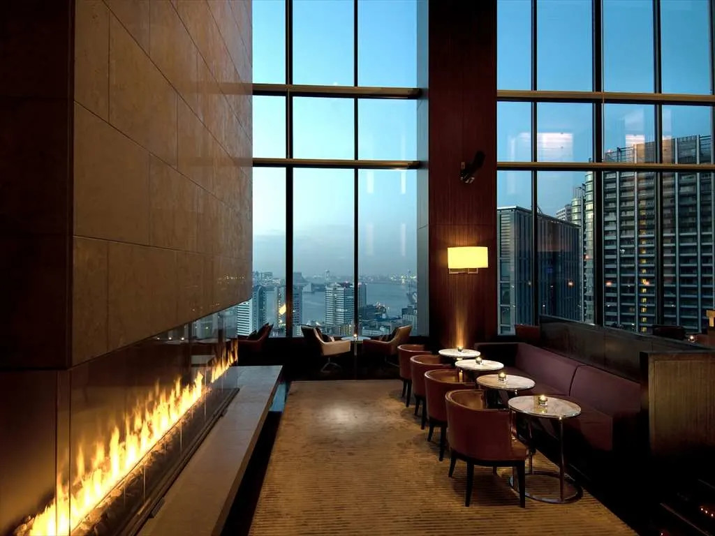 a modern fireplace in a dimly lit bar overlooking a city