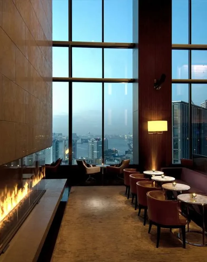 a modern fireplace in a dimly lit bar overlooking a city