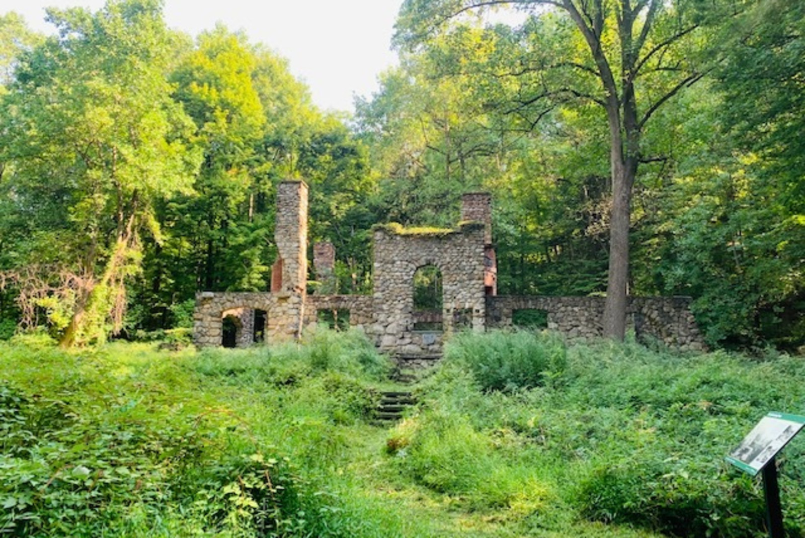 Stone structure surrounded by green grass and trees during daytime