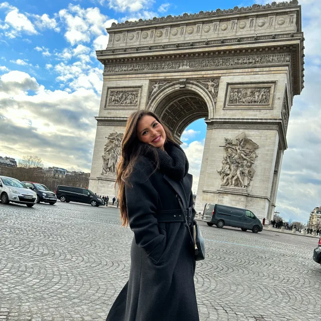 Travel Advisor Natalie Balladarsch in a black coat on cobblestone streets in Paris.
